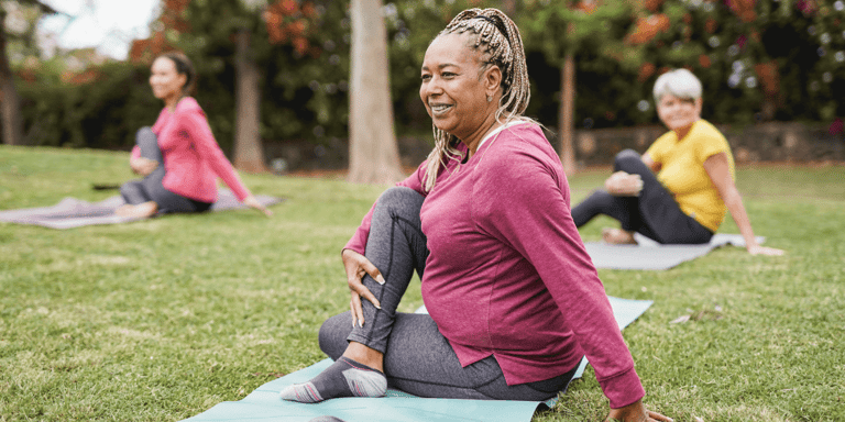 A group of diverse women doing yoga outdoors
